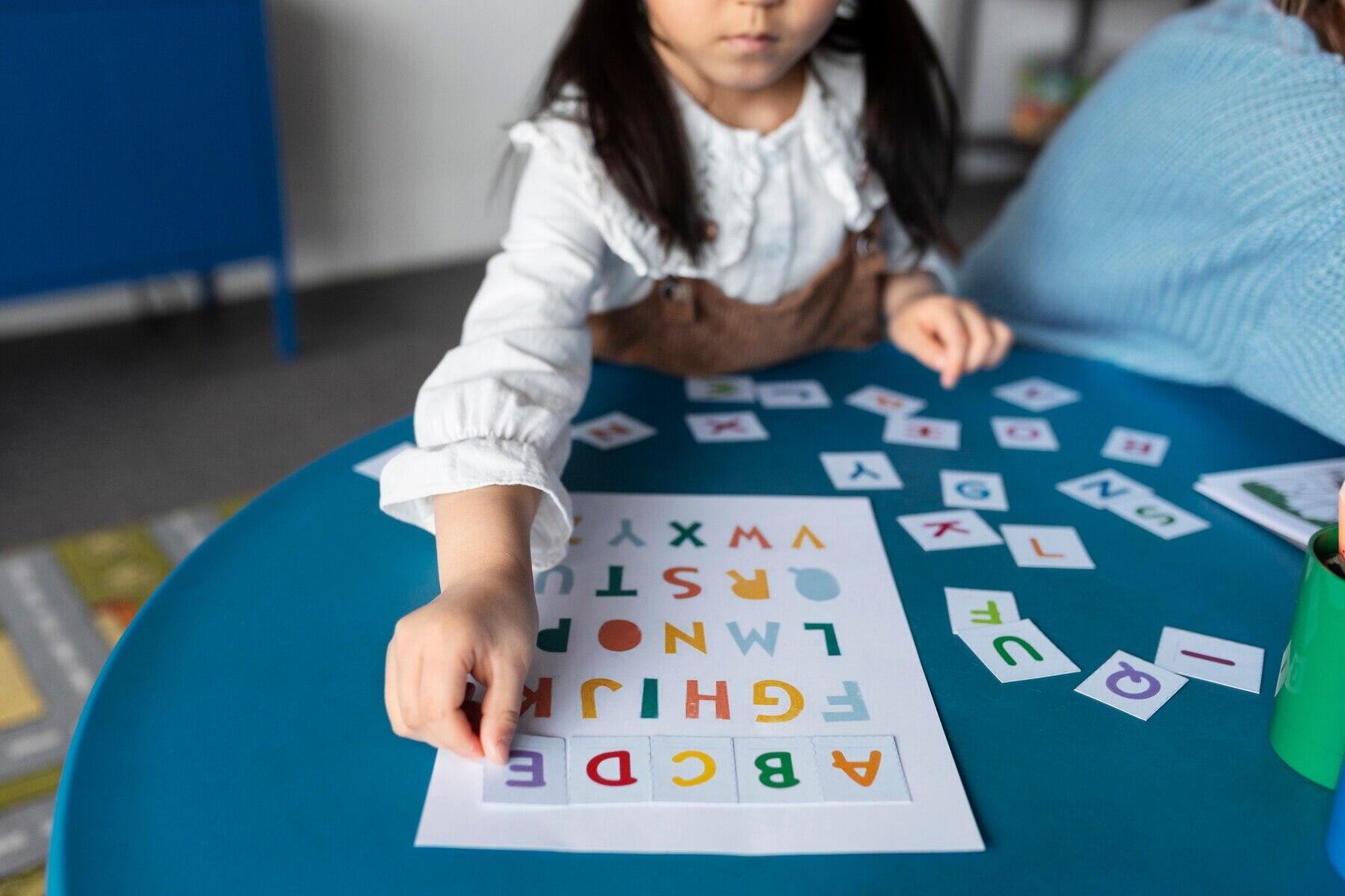 medio rostro de niña ordenando las letras del abecedario en una hoja