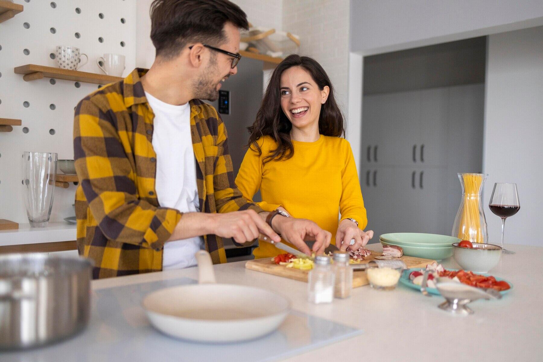 pareja sonriendo y cocinando