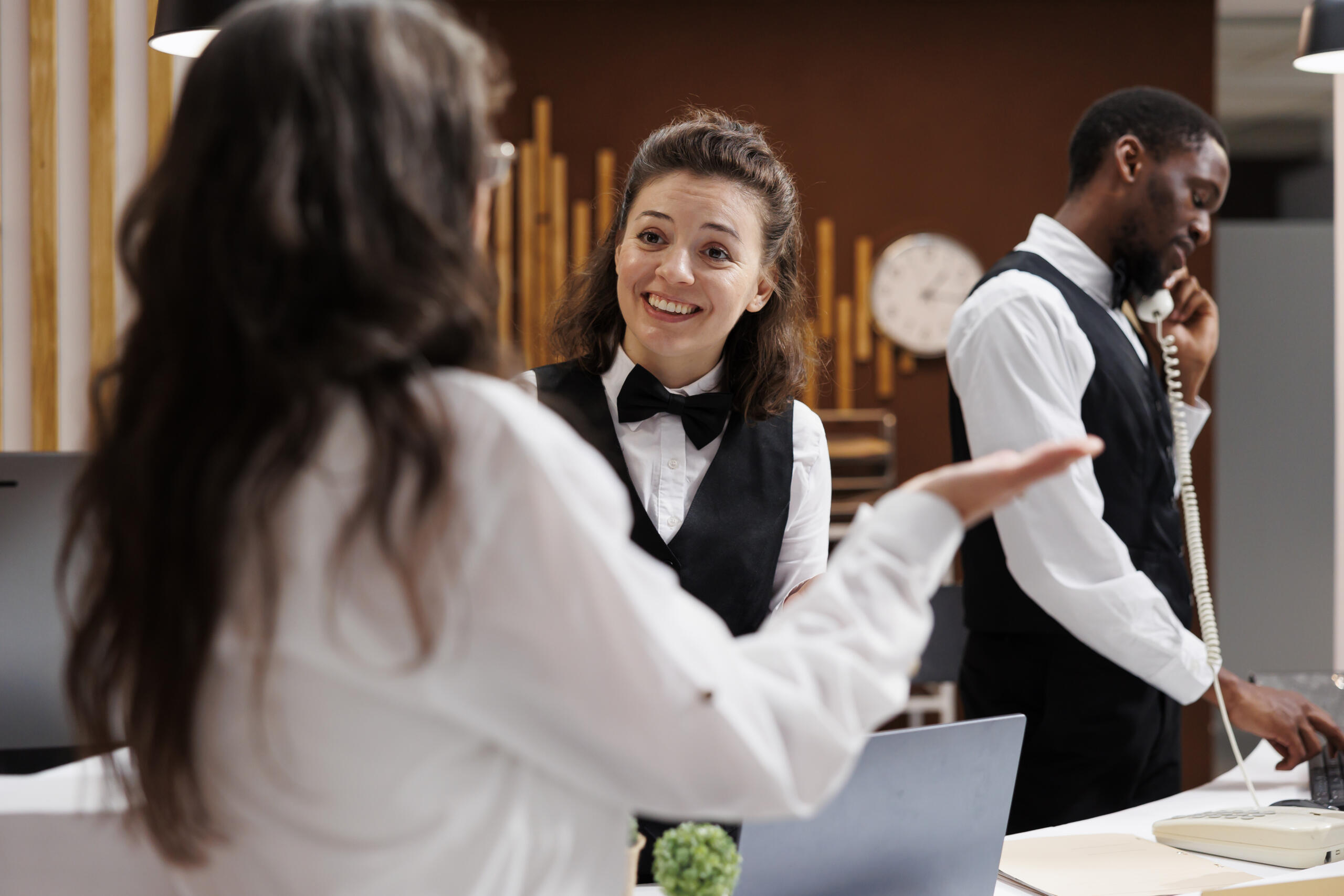 vista de una recepcionista de hotel sonriente atendiendo a un cliente