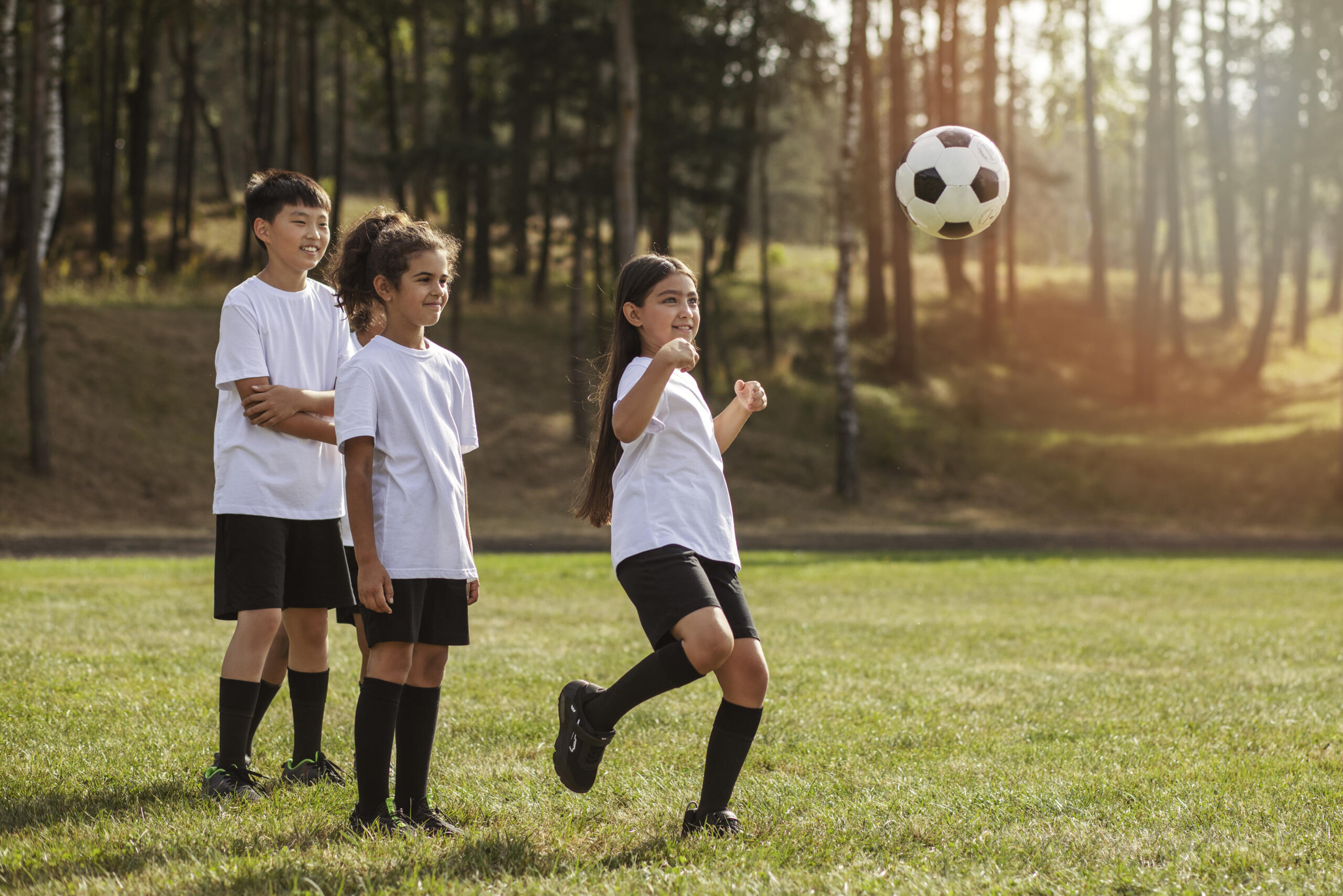 niños en fila haciendo esperando su turno para patear la pelota