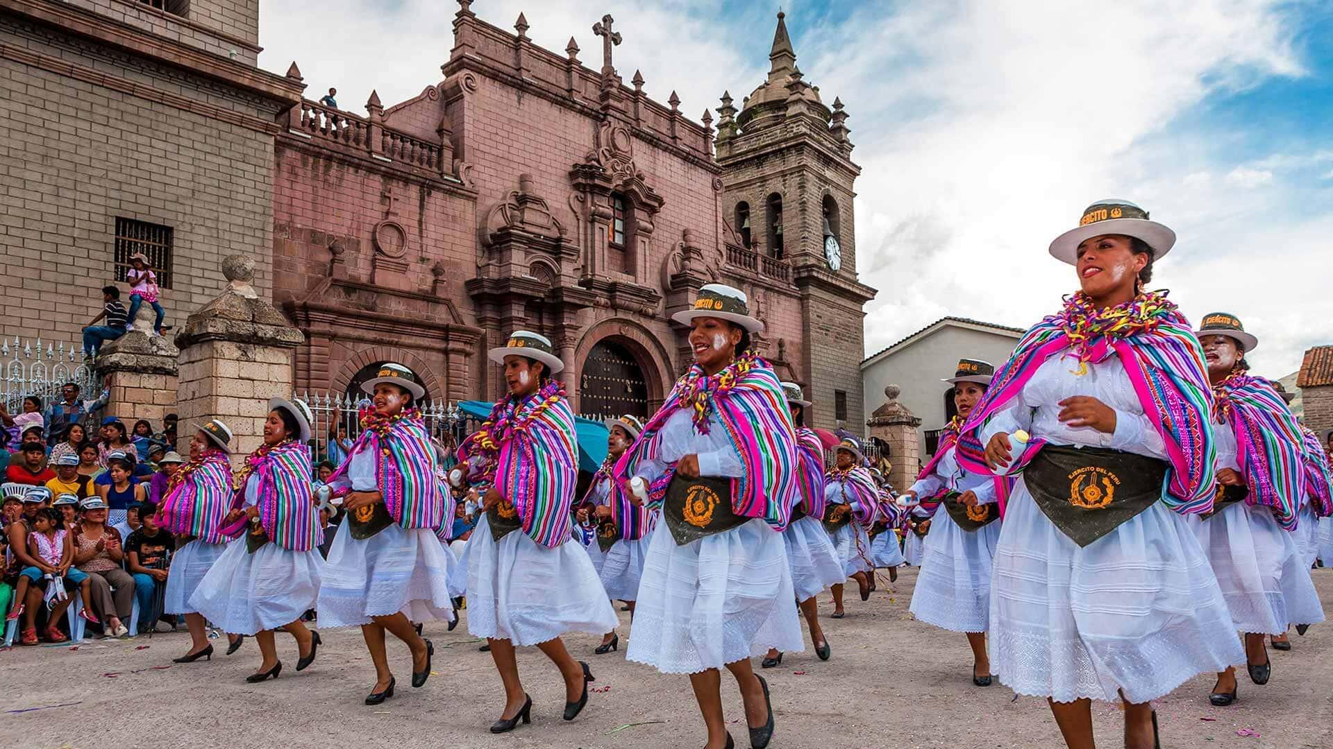 danzantes mujeres con trajes tipicos frente a una iglesia ayacuchana