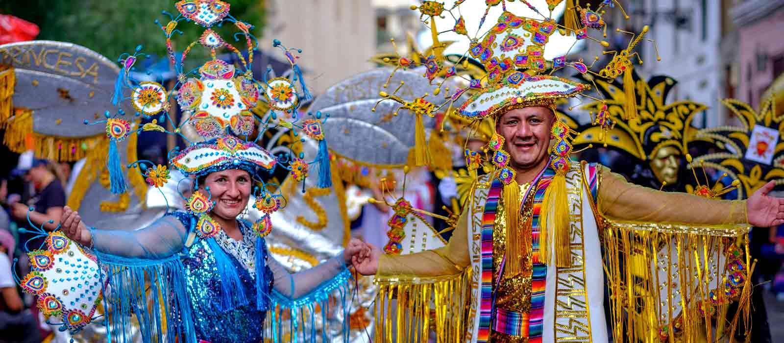 vista de hombre y mujer tomados de la mano y sonrientes con trajes típicos del corso de carnavales en Cajamarca