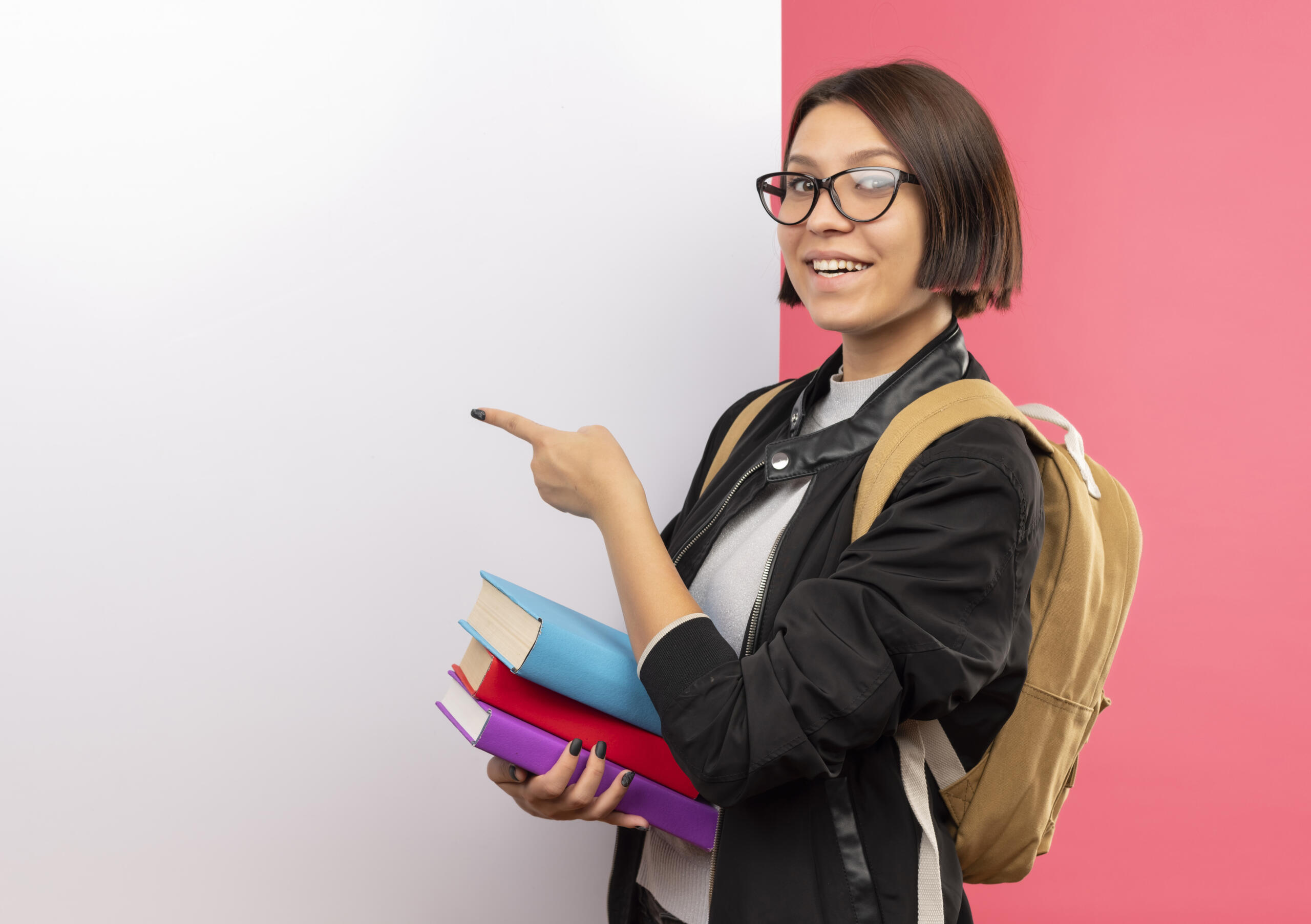 estudiante con libros en brazos señalando una pizarra en blanco