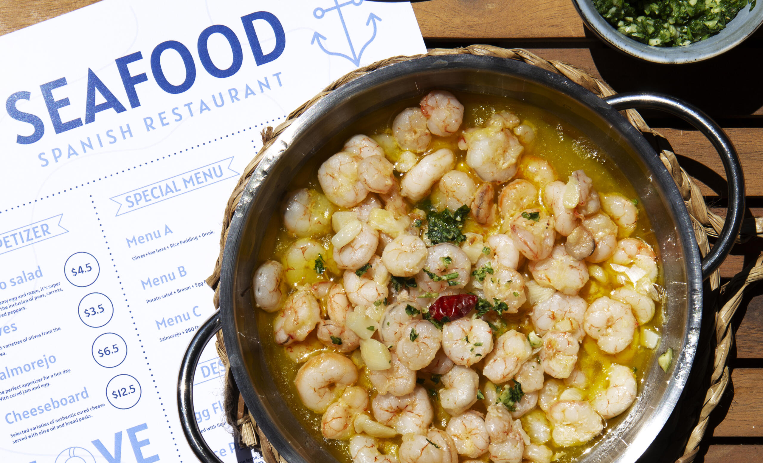 vista cenital de un plato de mariscos junto a una carta en inglés de un restaurante seafood