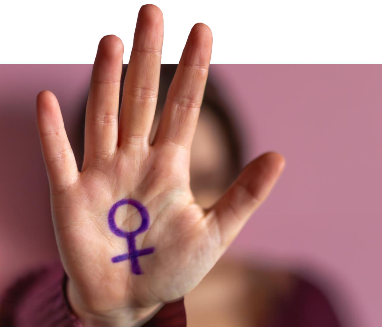 mano saliendo de la foto con un símbolo feminista pintado en morado en la palma