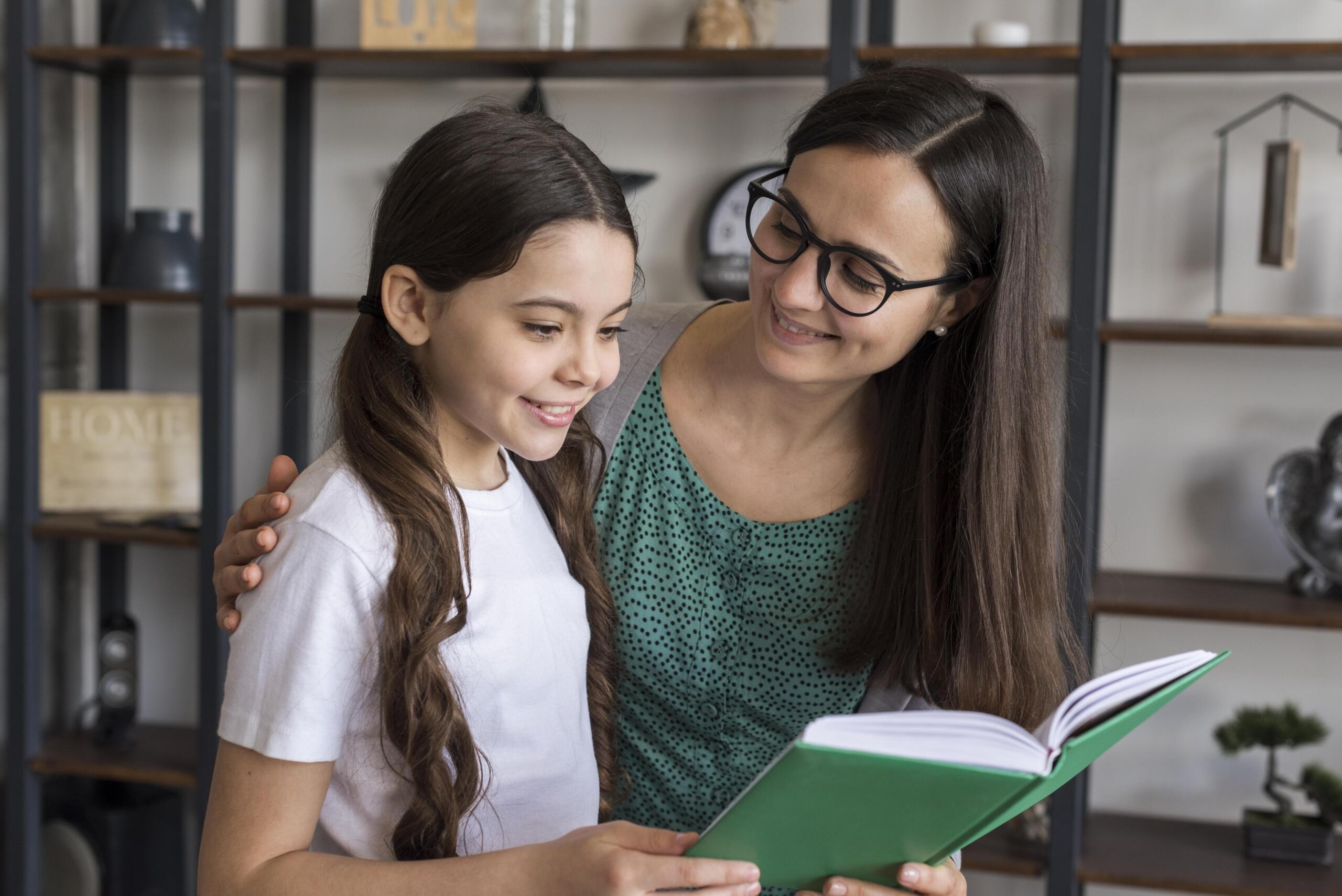 profesora junto a una niña leyendo un libro