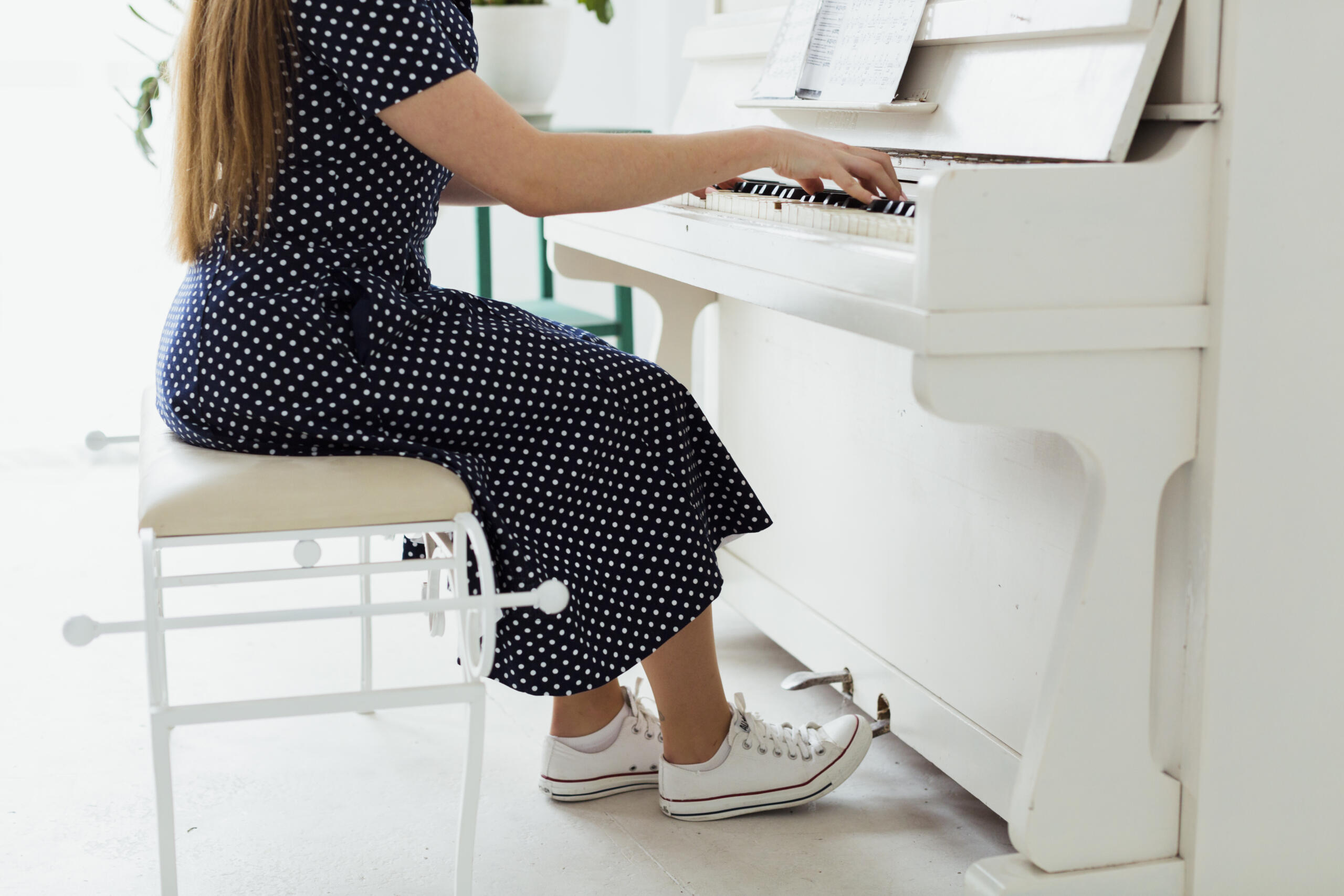 vista inferior de mujer tocando un piano blanco