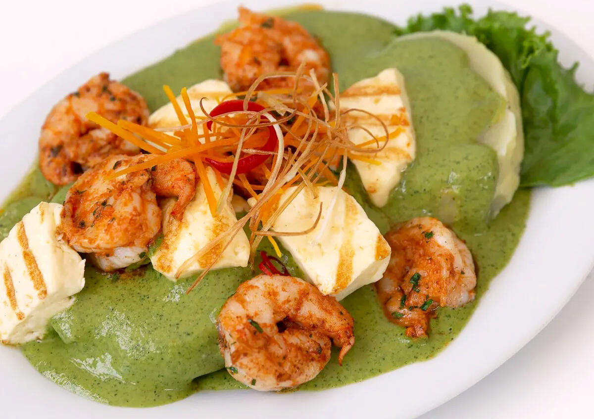 vista cenital de plato con ocopa con langostinos y queso a la parrilla