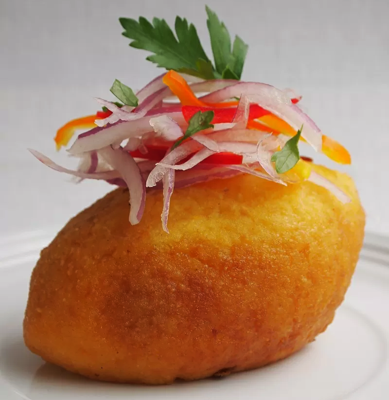 plato de papa rellena con su sarza de cebolla decorada encima