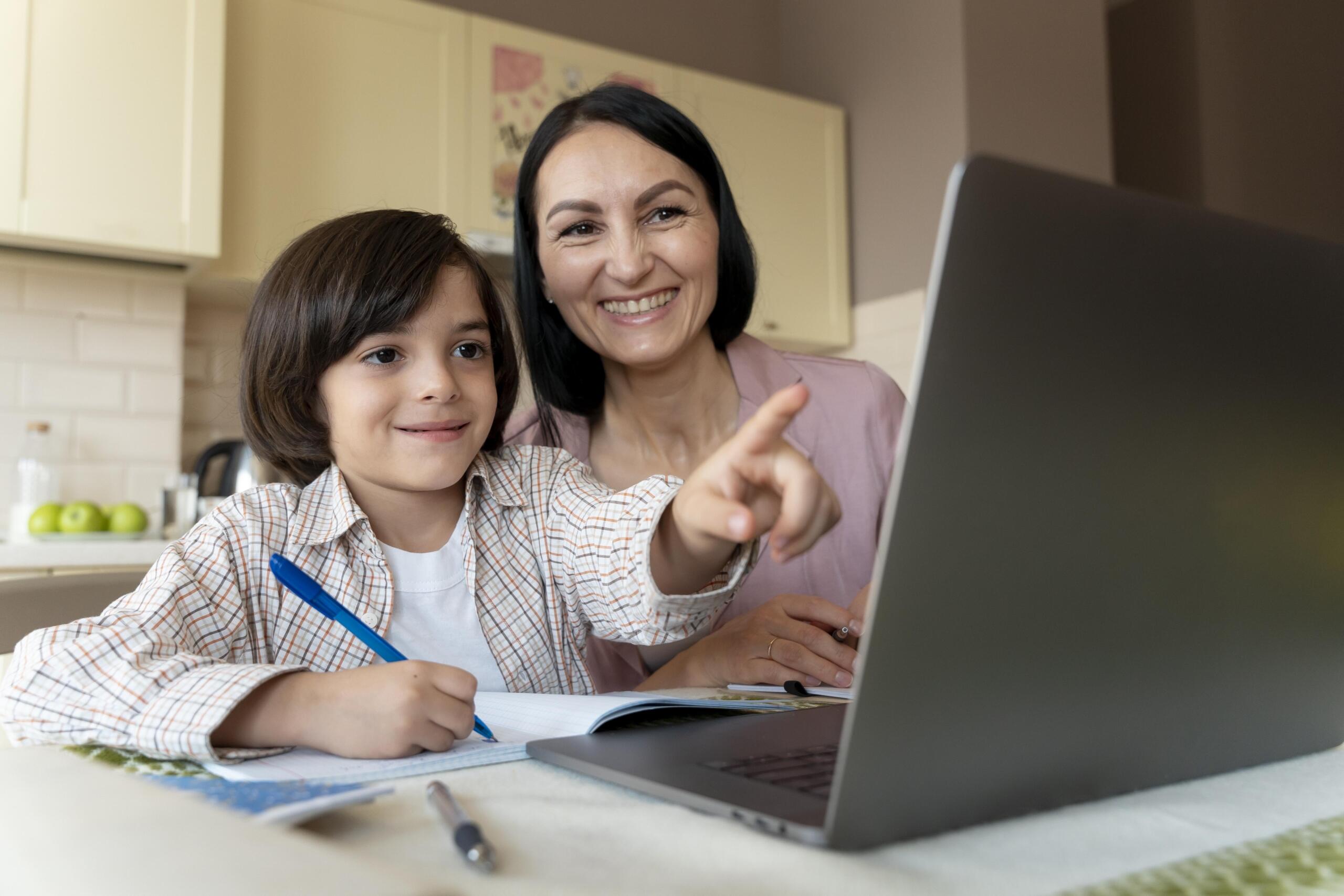 niño estudiando frente a una laptop con su profesora