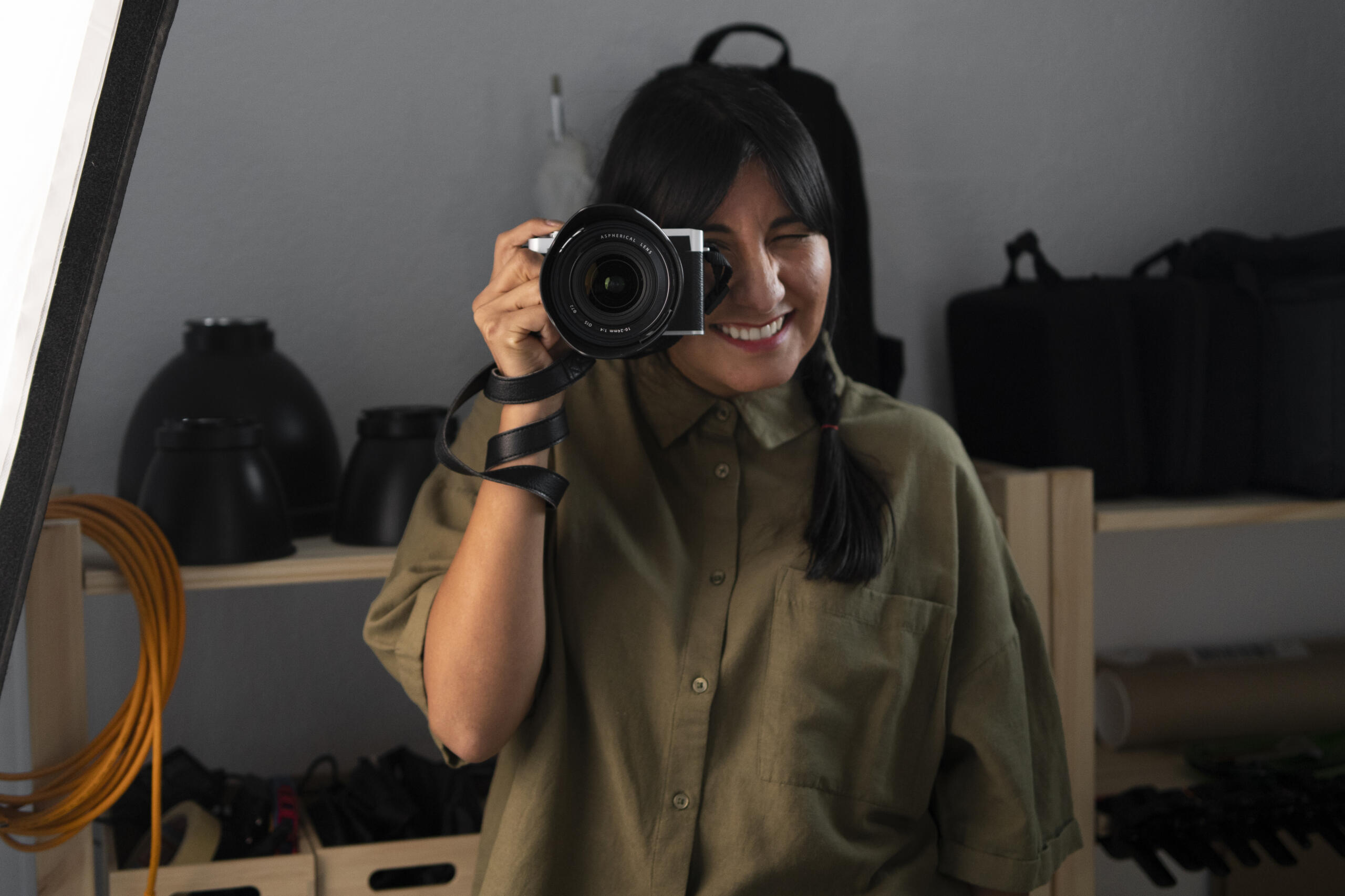 fotografa sonriente con la cámara en frente apuntando hacia el frente