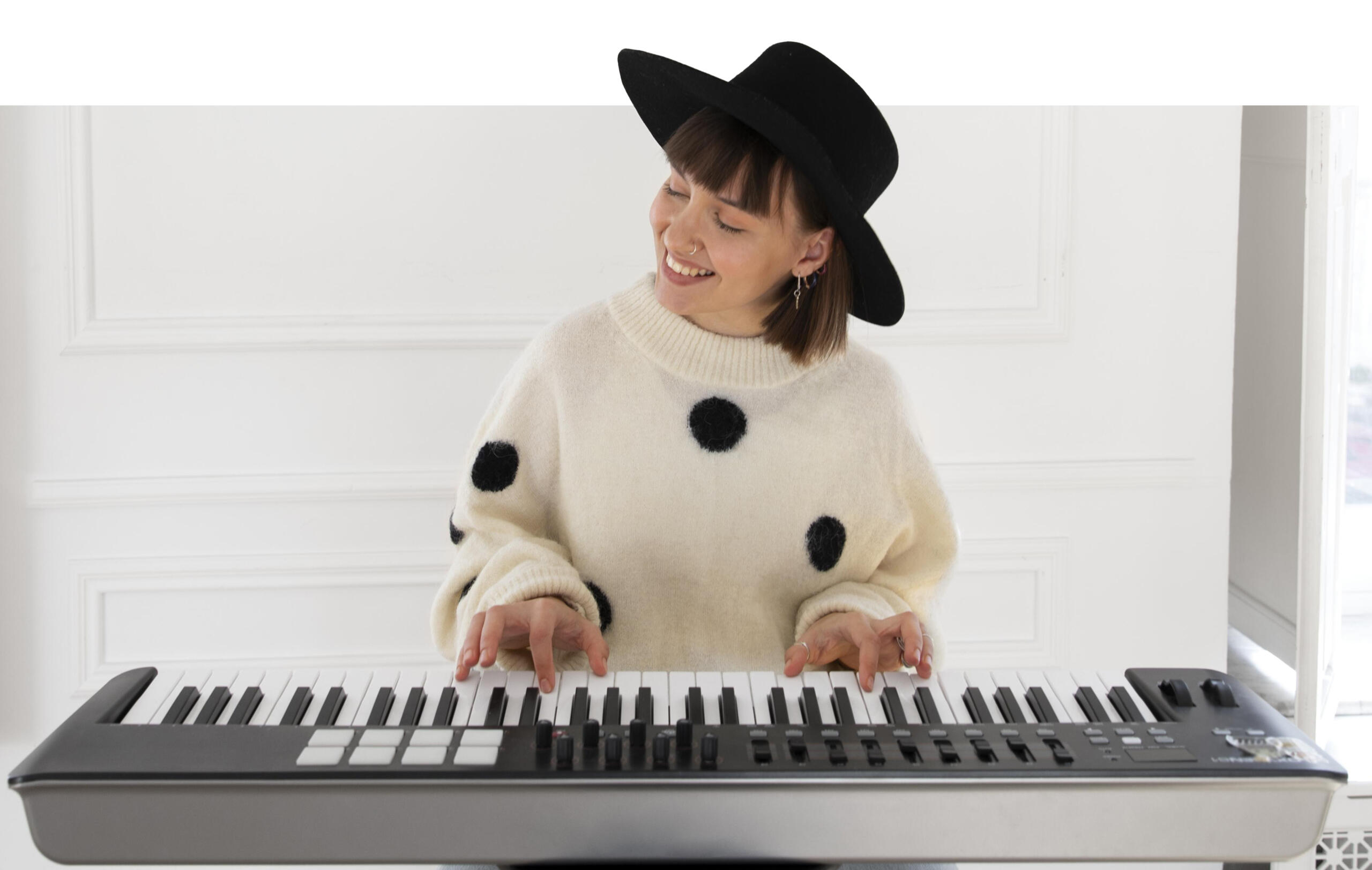 chica sonriente tocando un teclado electrónico