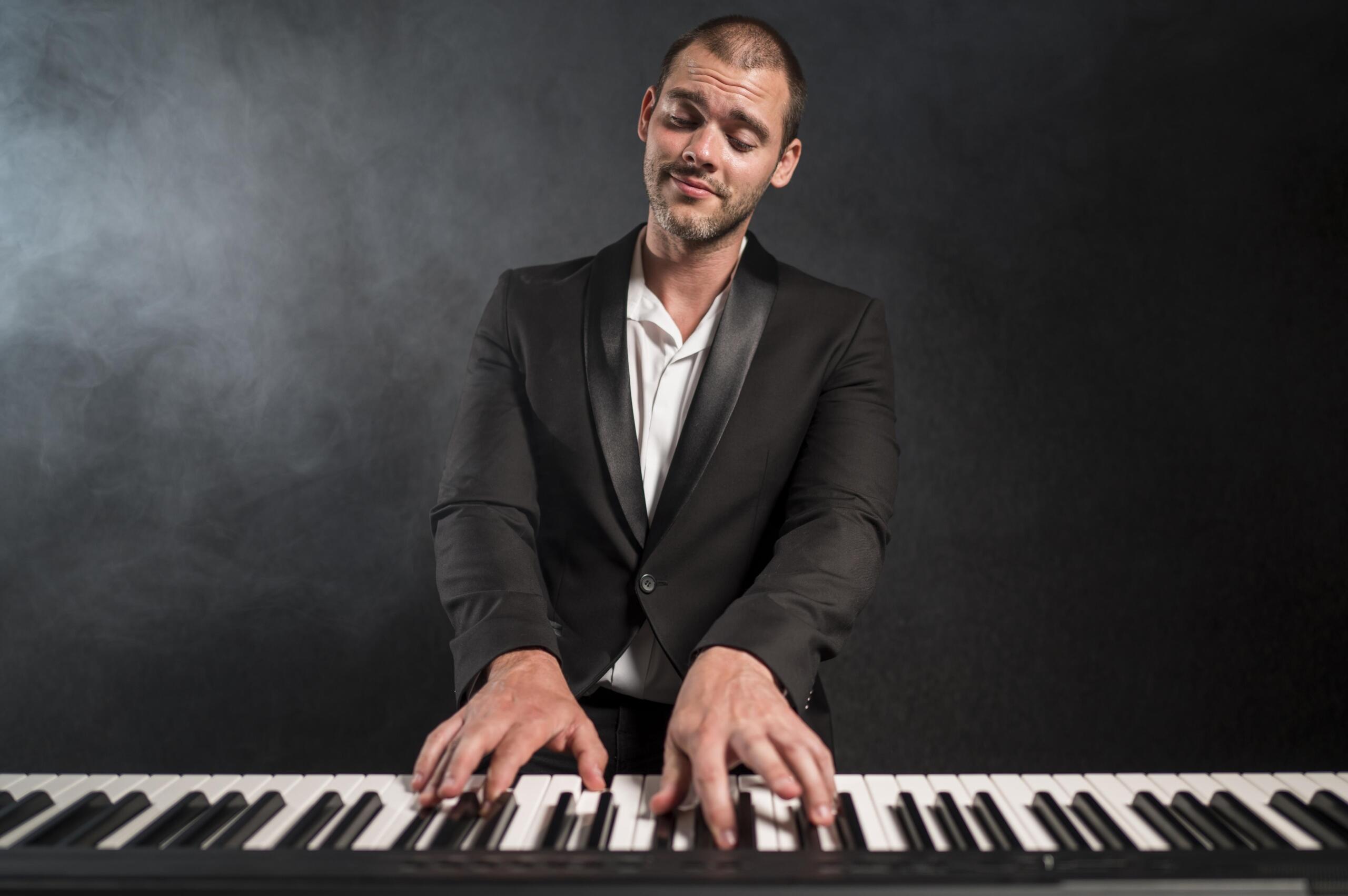 chico tocando el teclado electrónico sonriente con los ojos cerrados