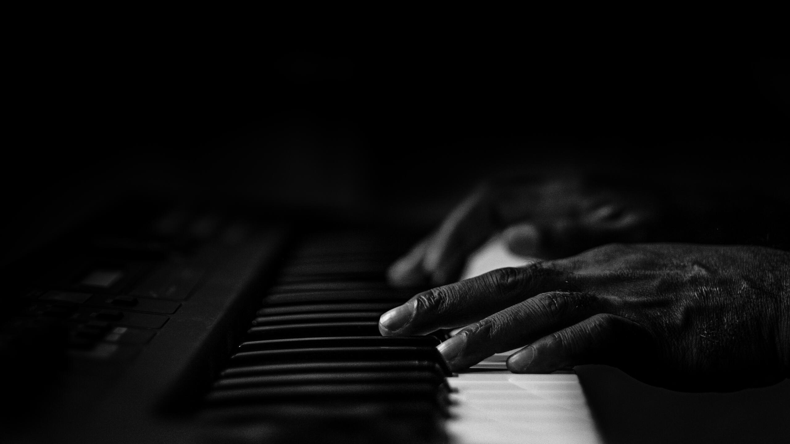 foto en en blanco y negro de manos de un adulto sobre un teclado electronico