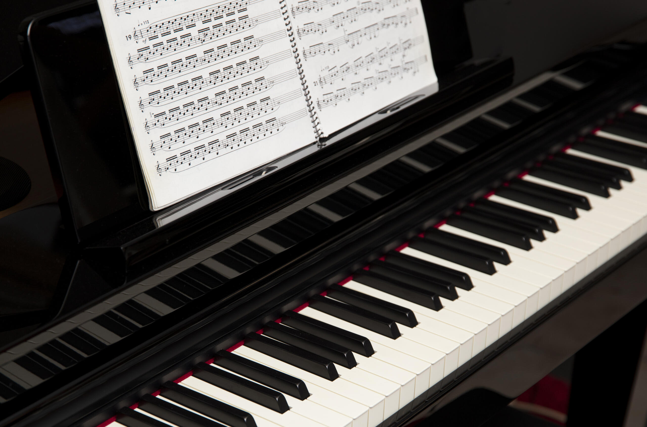 vista de lado de un piano con partituras sobe las teclas