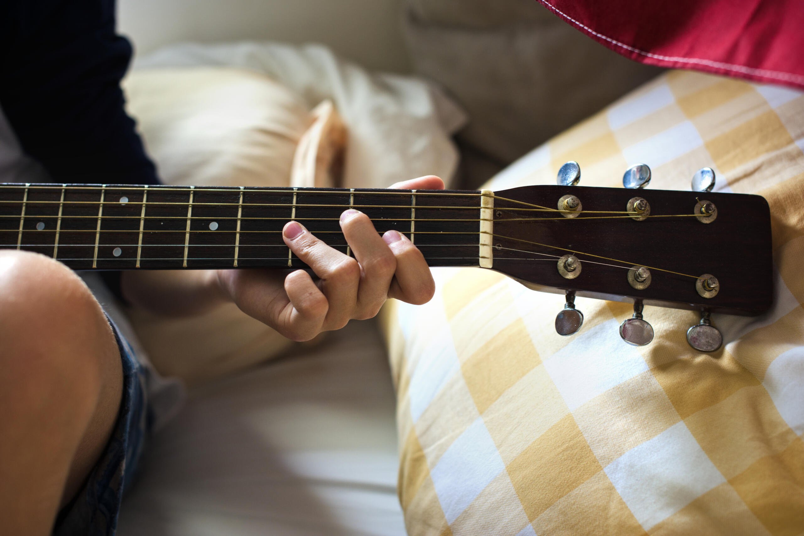 vista detalle de manos marcando los trastes de la guitarra para tocar