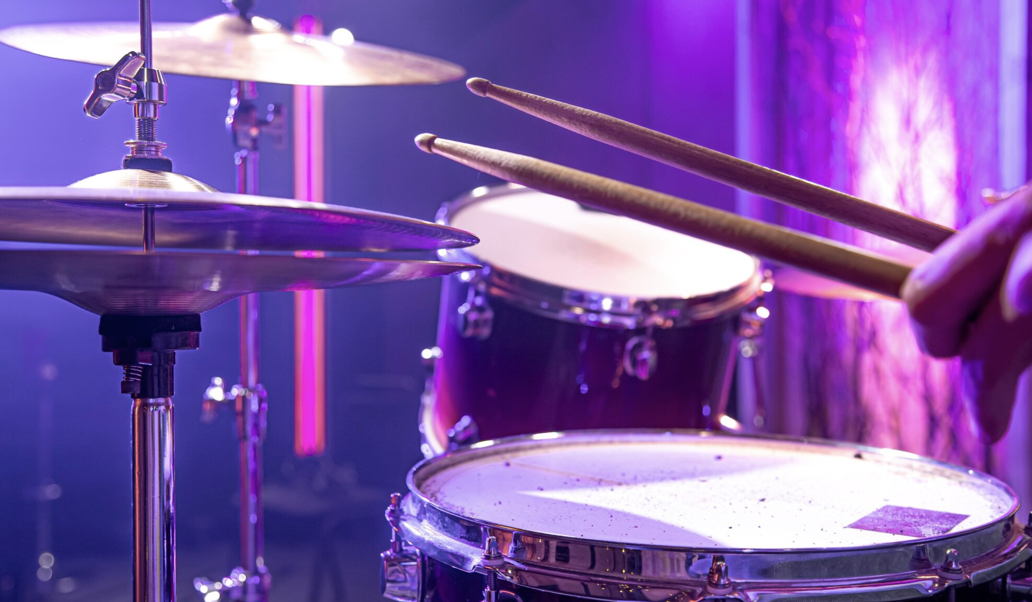 toma detalle de persona tocando la bateria con baquetas al aire
