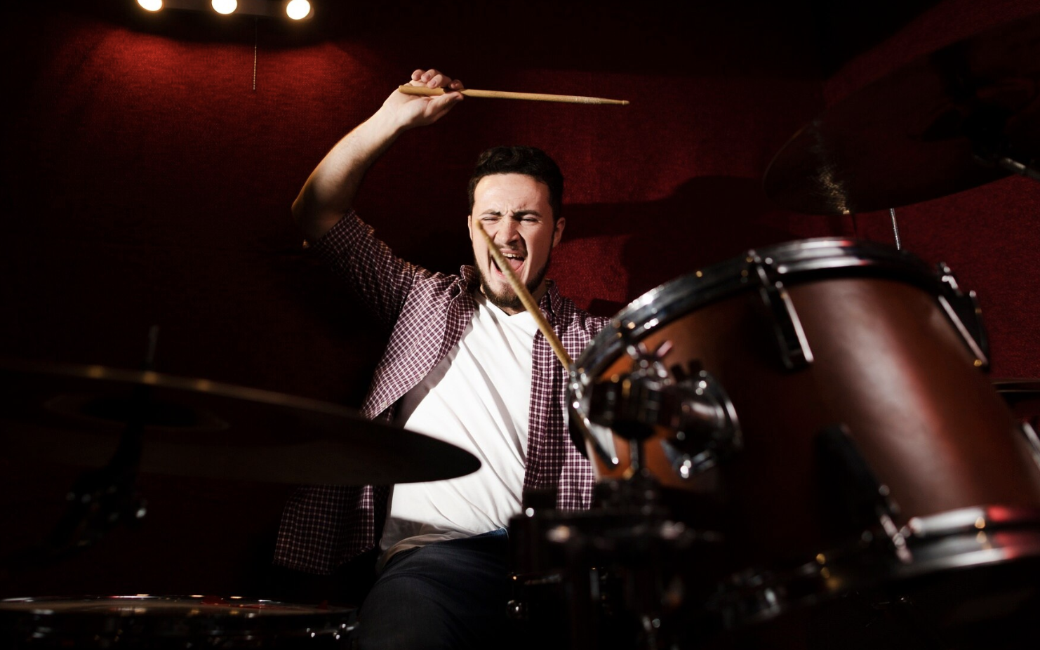 chico tocando la bateria alegre en un escenario