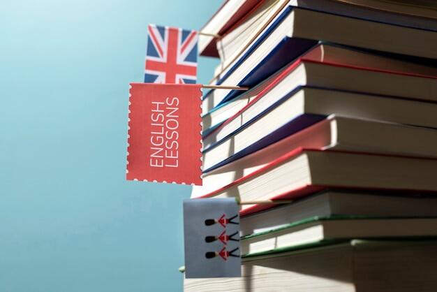 libros de inglés apilados con pequeños banderines ENGLISH LESSONS y soldados ingleses puestos entre algunos 