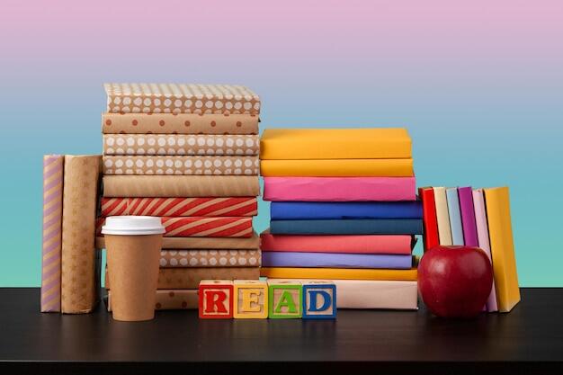 bodegón de libros apilados y cubitos para niños con la palabra READ formada
