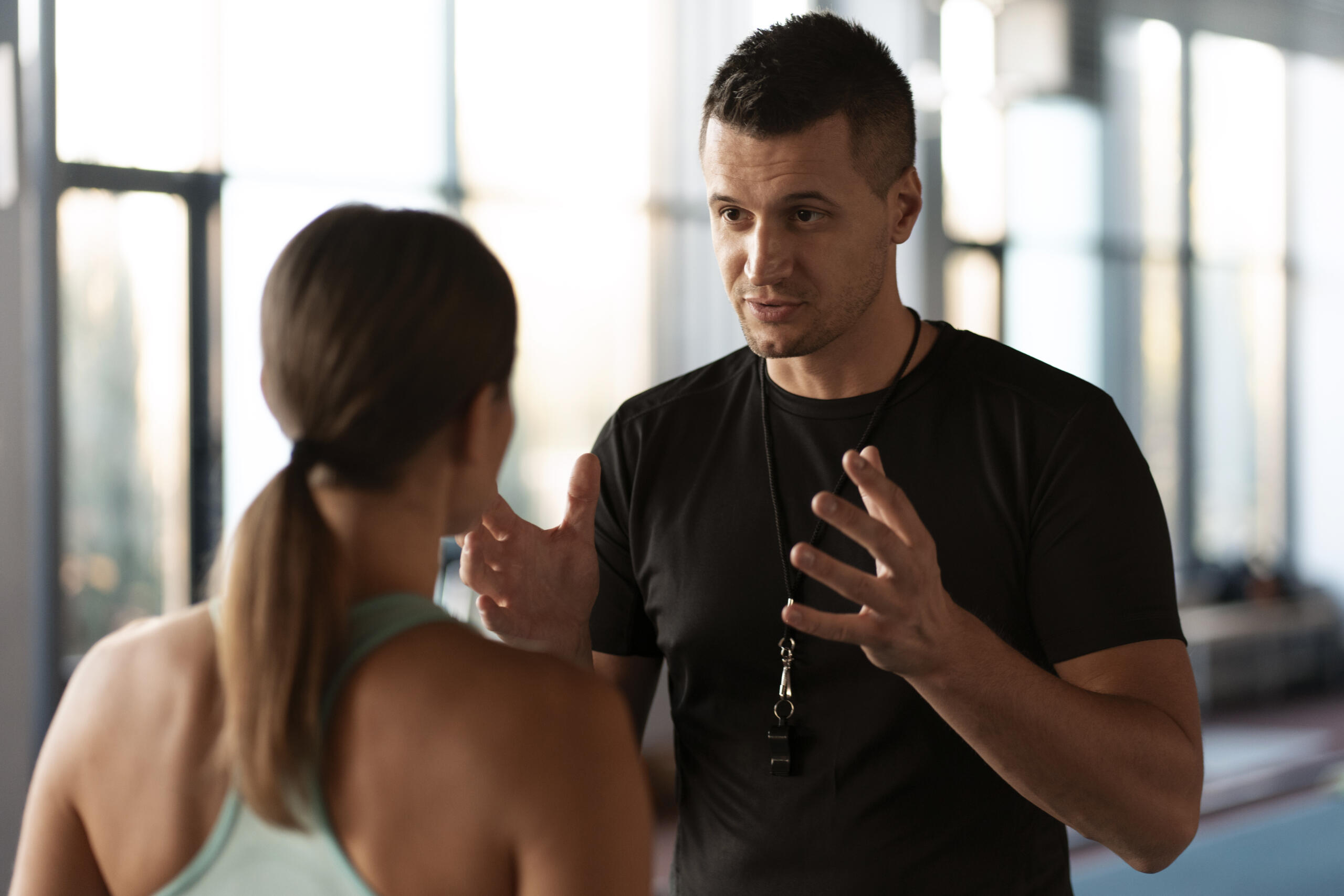 entrenador hablando con una chica que está de espaldas a la cámara