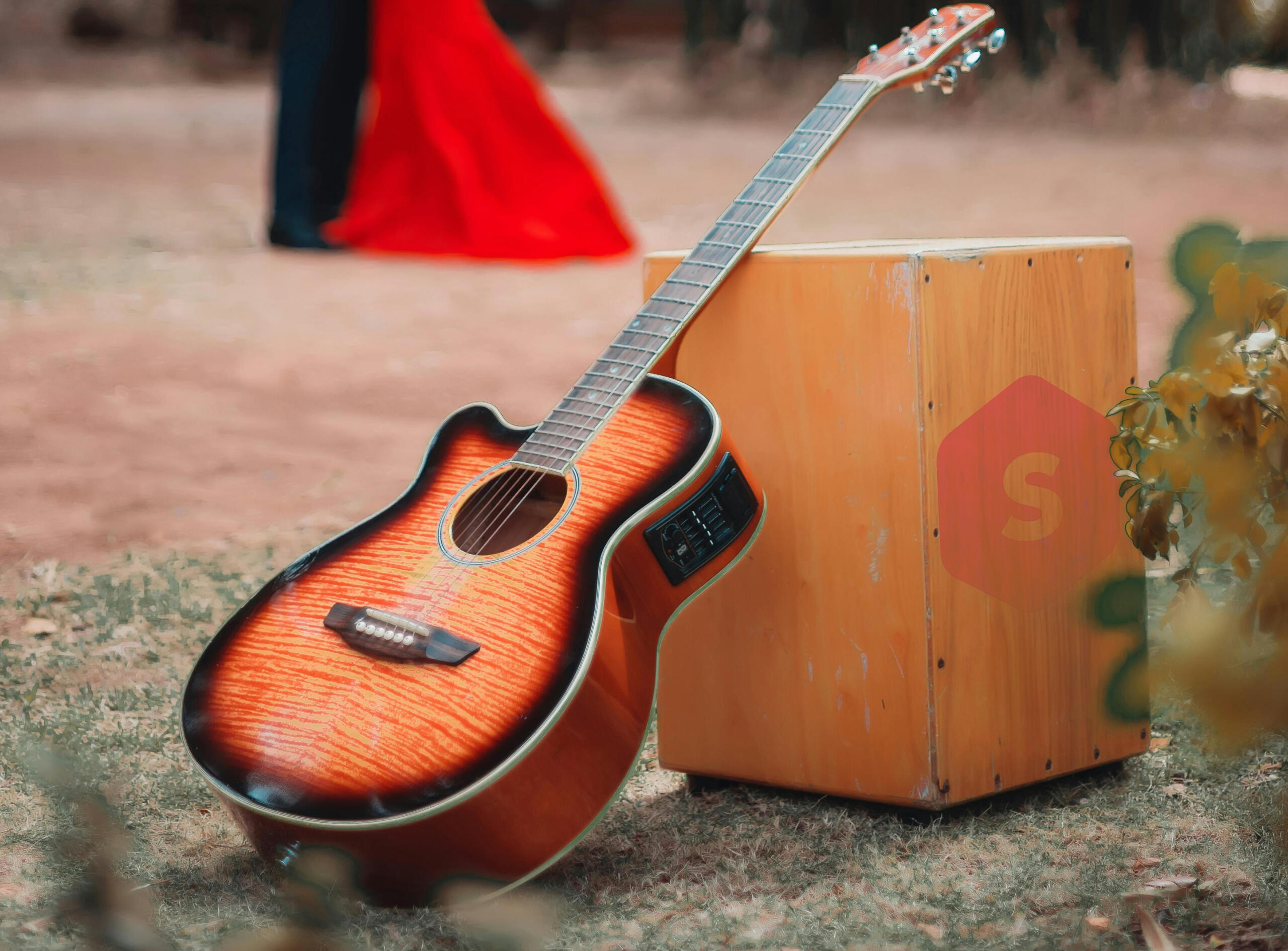 guitarra peruana y cajon peruano solos en primer plano con el logo de superprof a un lateral y vista de una pareja bailando en el fondo