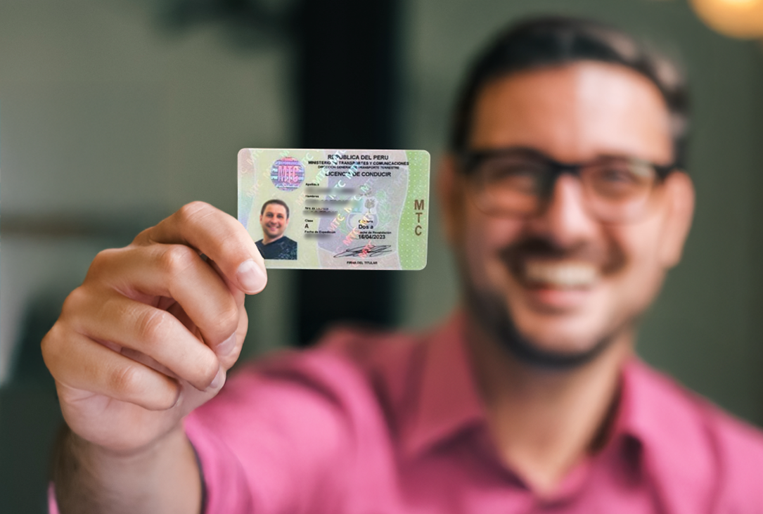 brevete peruano en primer plano con rostro sonriente del chico que lo sostiene en fondo desenfocado