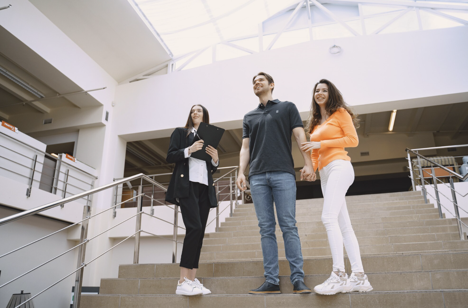 tres personas en las escaleras de una universidad