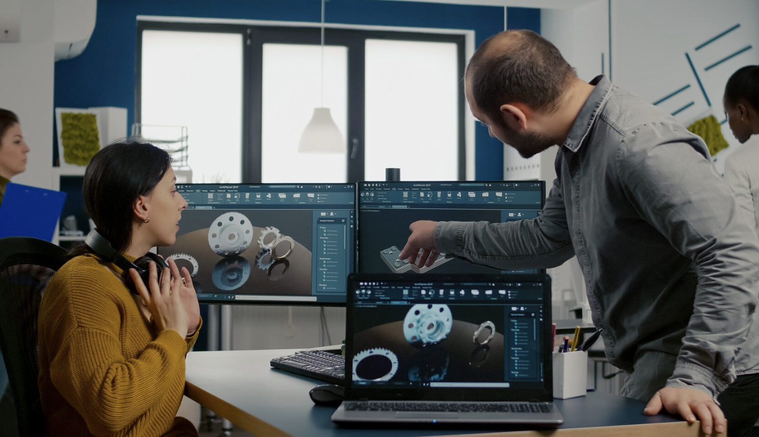 grupo de chicos en un salon de clase mirando una pantalla con un programa de modelado abierto