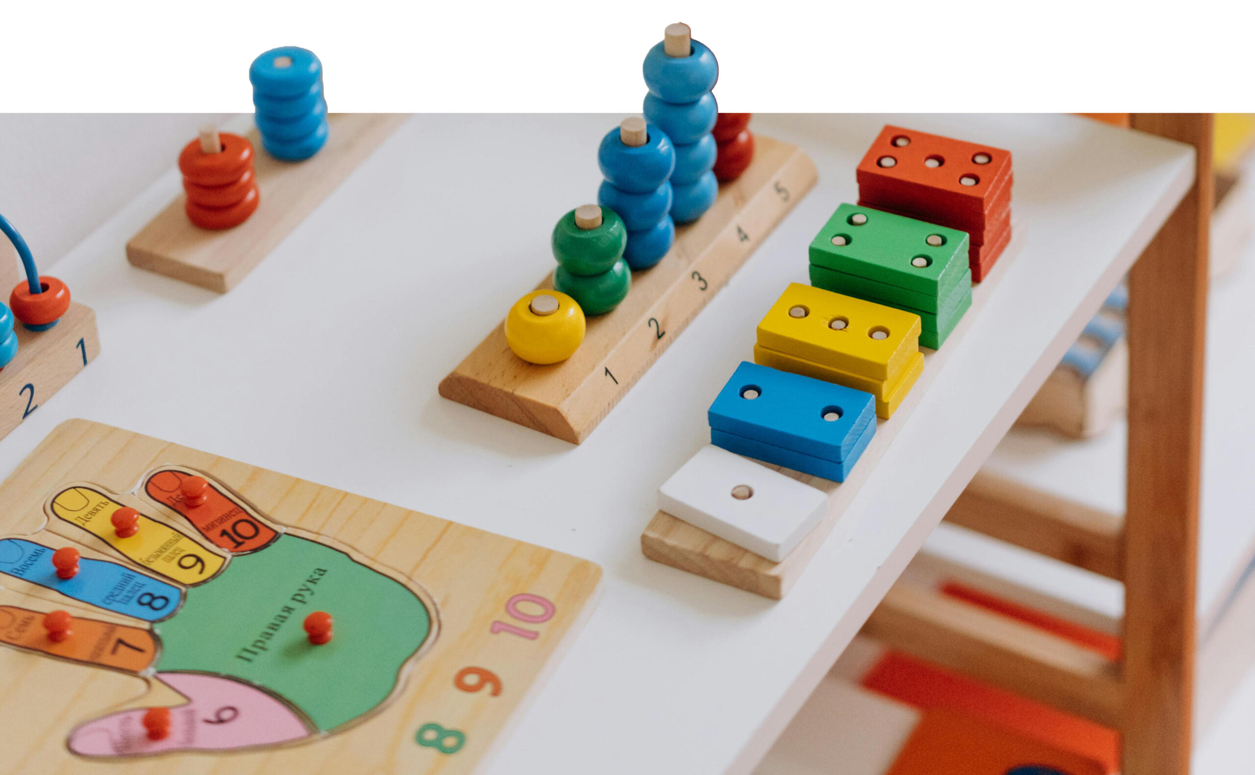 mesa llena de juguetes Montessori y parte de ellos parecen salirse de la imagen