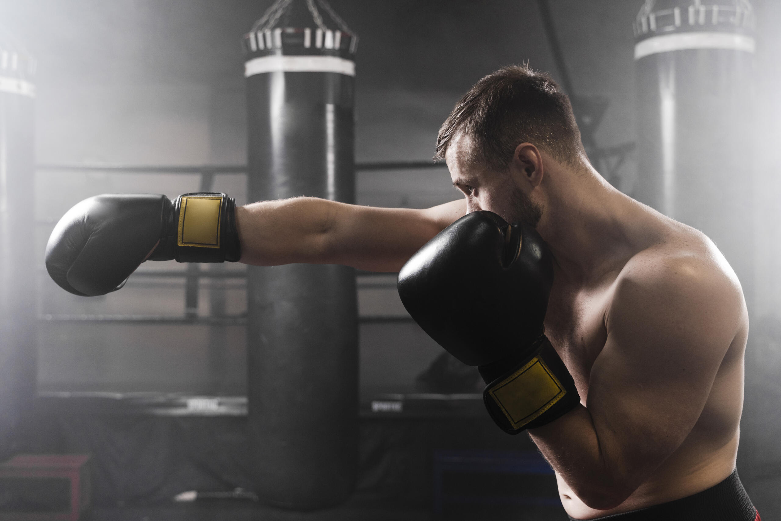 chico con guantes de boxeo extendiendo un puño de perfil
