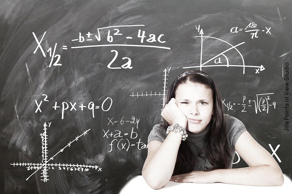 Uczennica na tle tablicy zapisanej równaniami matematycznymi