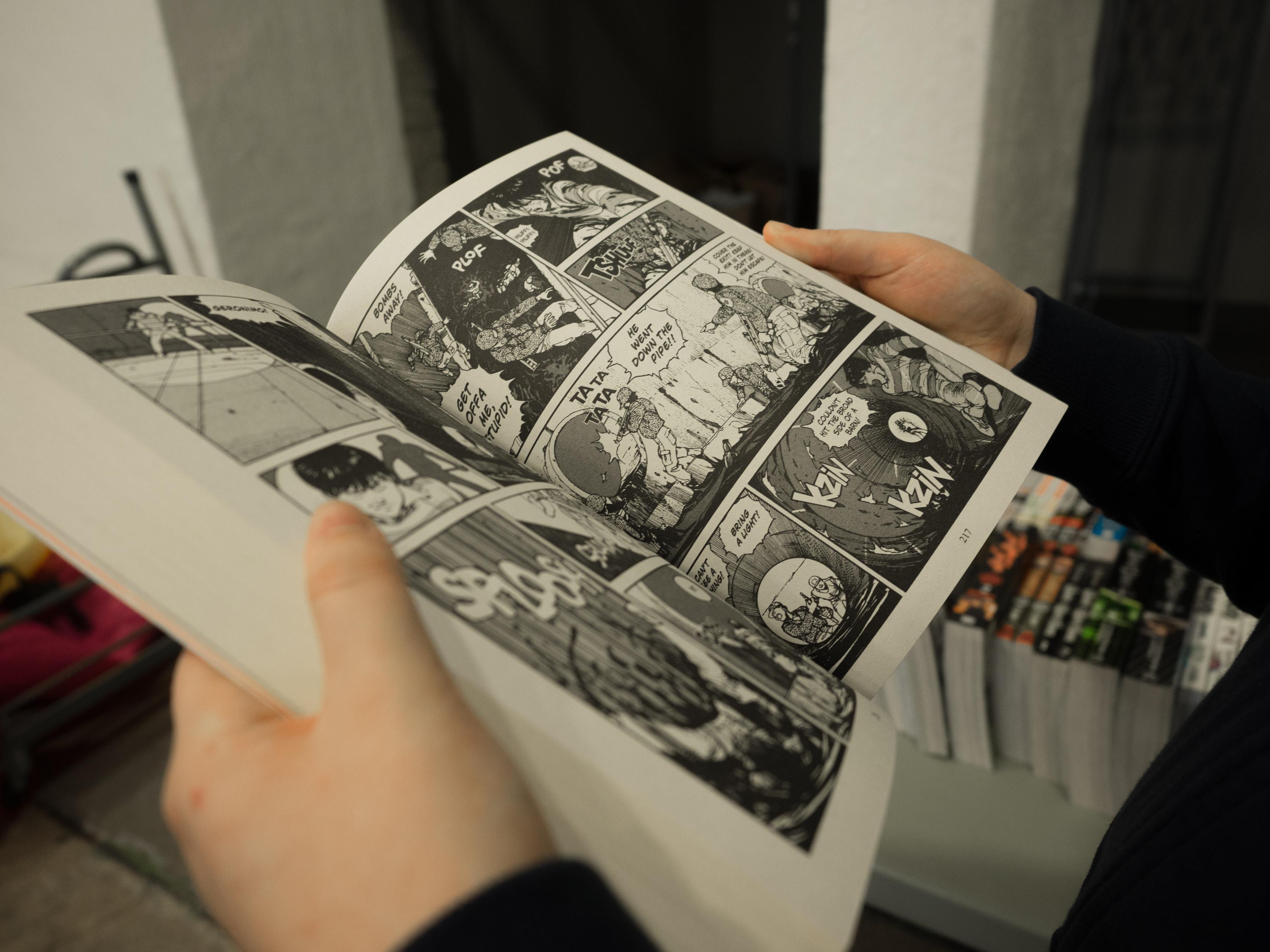 Osoba przeglądająca magę japońską, komiks.