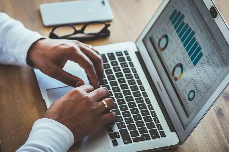 Mężczyzna pracujący nad statystykami na laptopie
