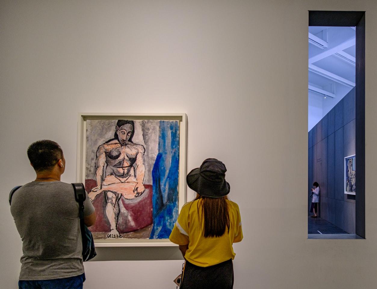 kobieta i mężczyzna oglądający obraz picassa w muzeum