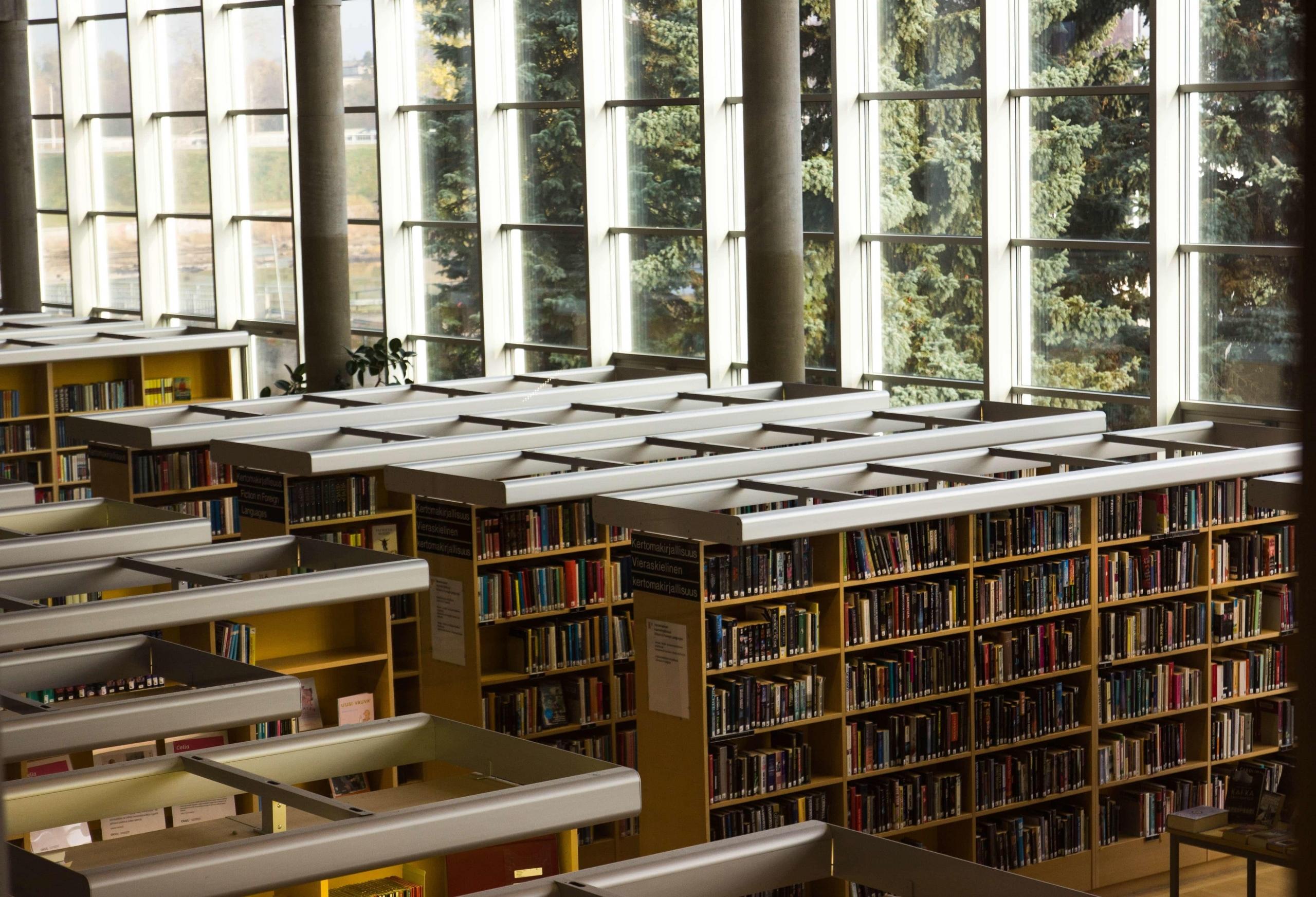 Półki z książkami w oszklonej bibliotece.