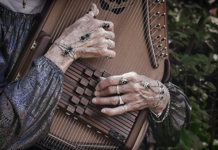 starsza kobieta grajaca na instrumencie