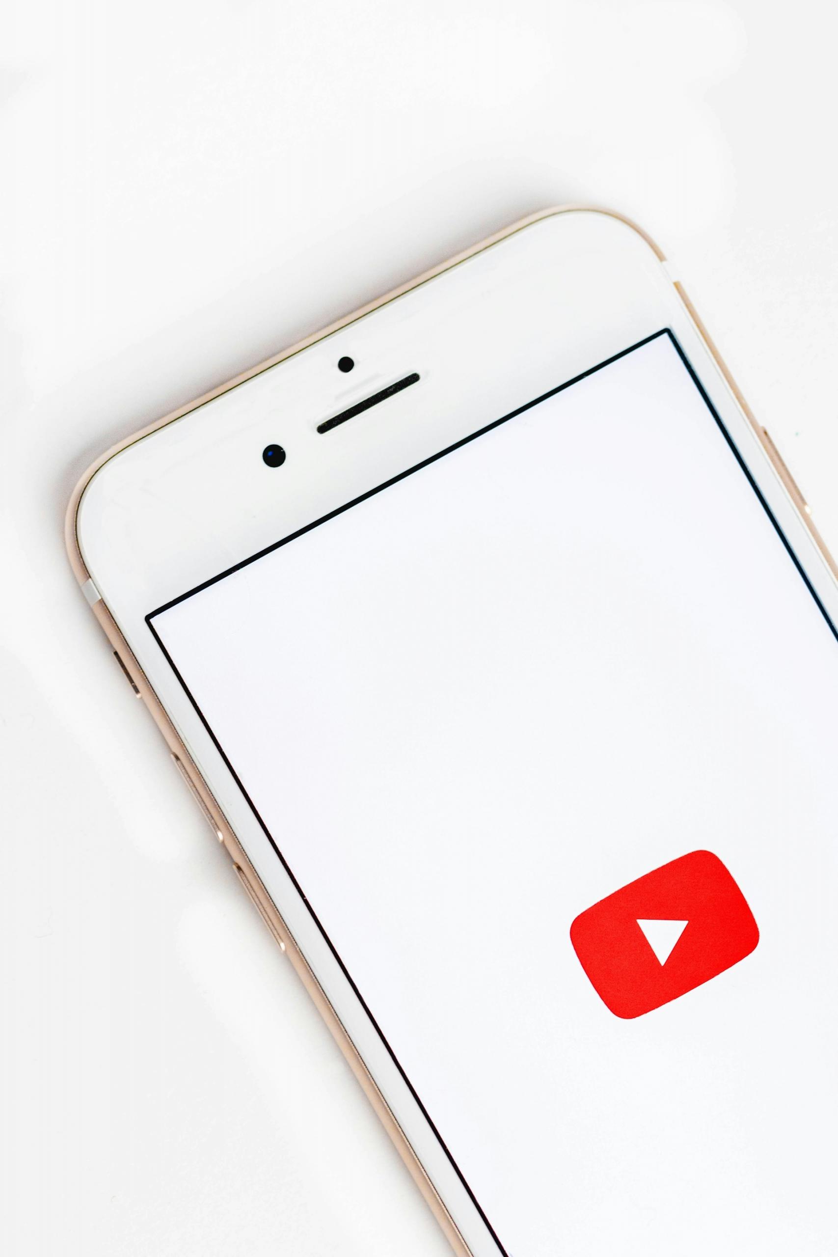 Logo platformy YouTube na białym tle na ekranie smartfona.