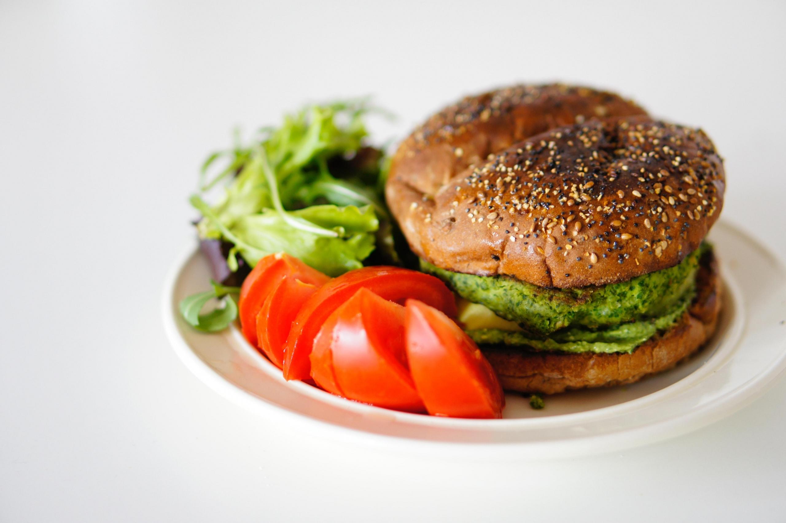 Burger wegetariański z pomidorem i sałatą.