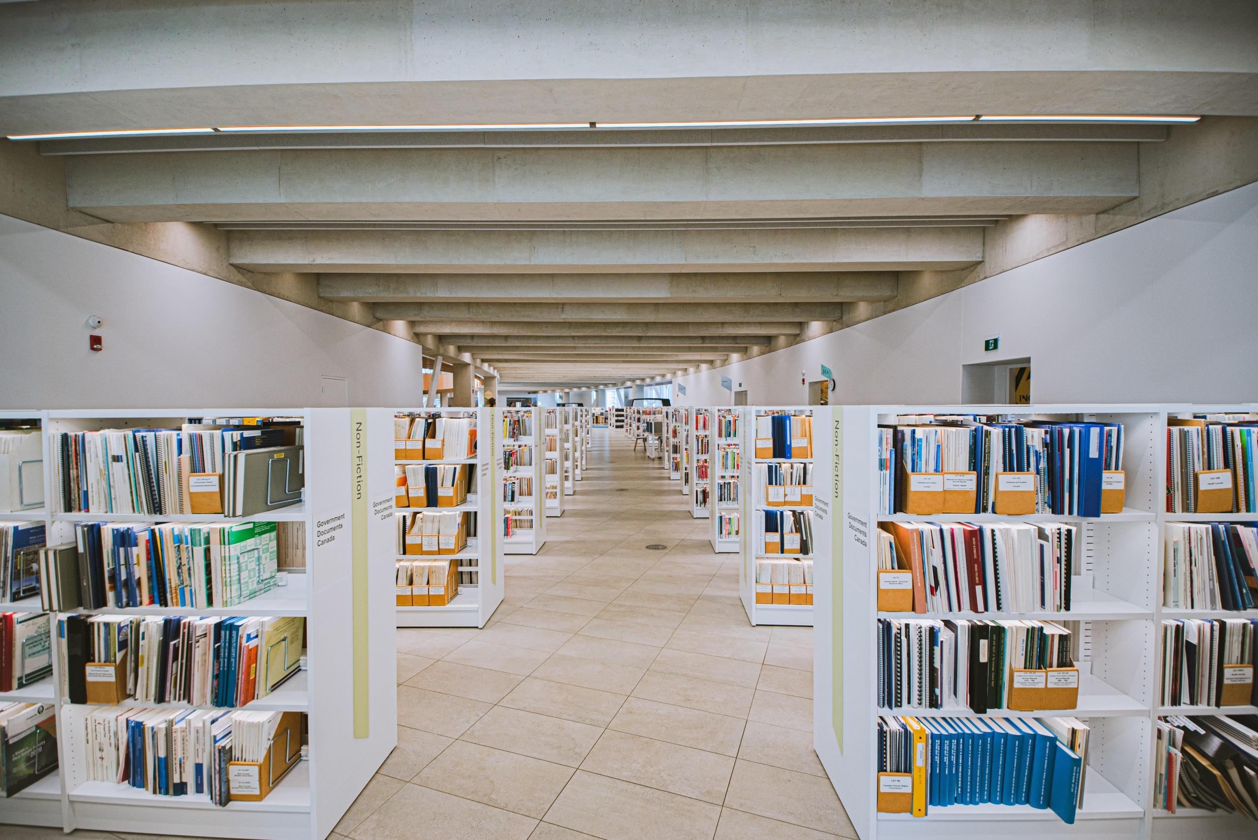 Białe regały z książkami w bibliotece.