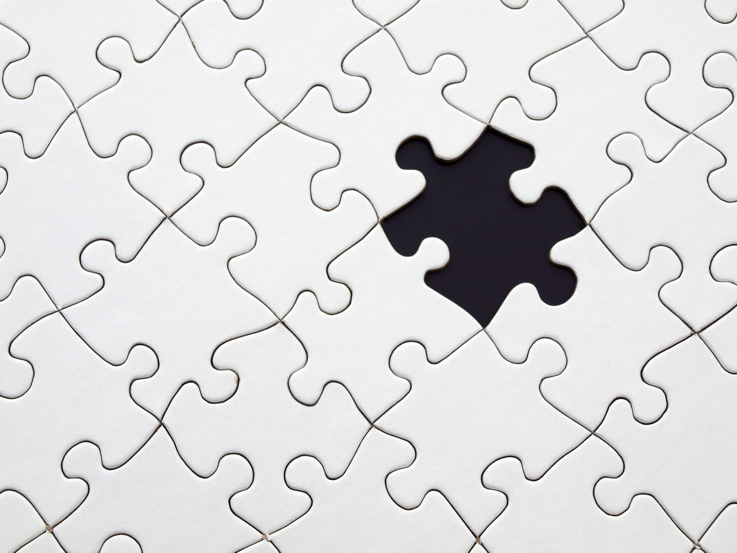 Białe puzzle z brakującym elementem.