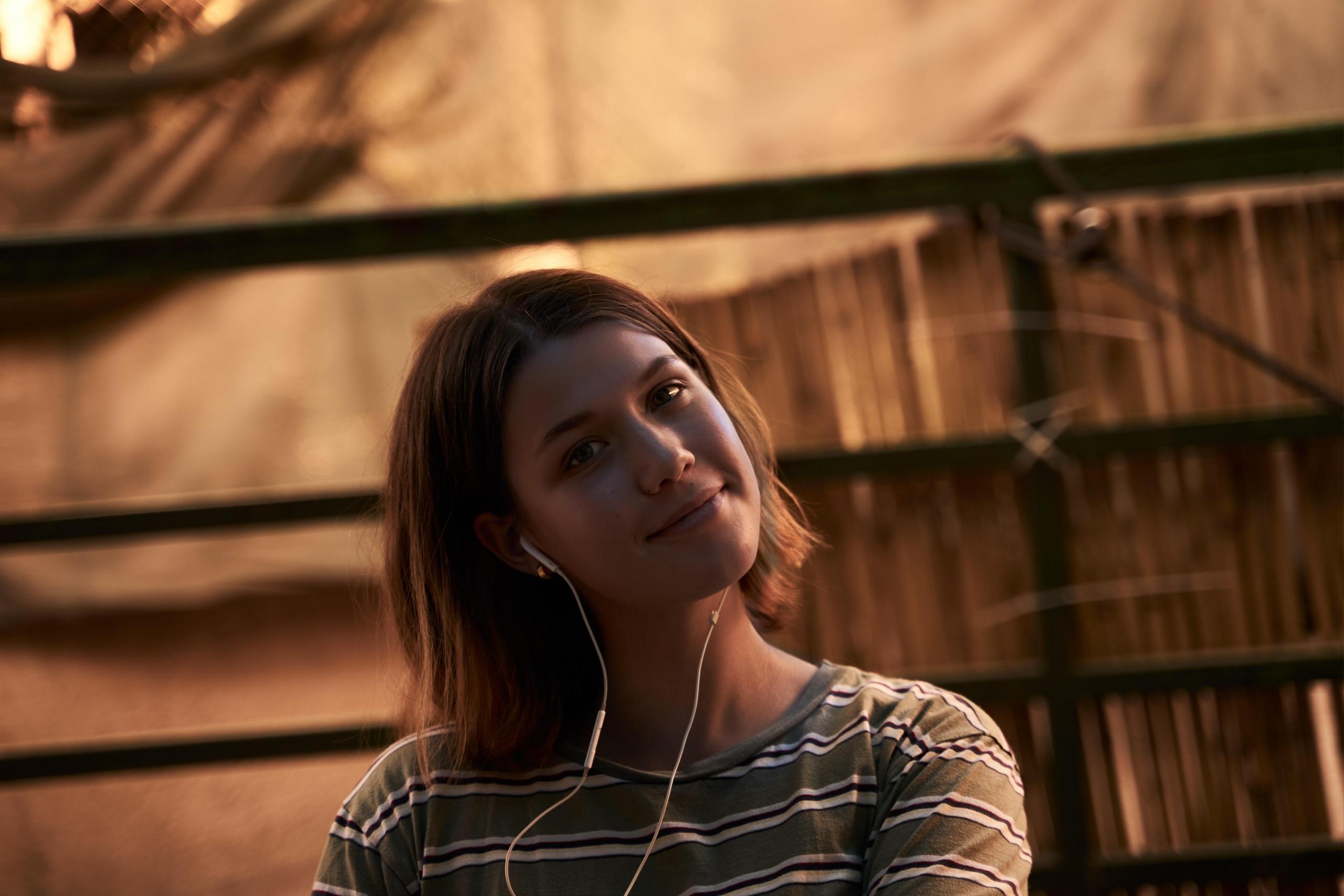 Uśmiechnięta dziewczyna ze słuchawkami.