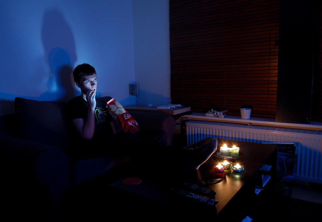 mężczyzna jedzący przekąski przed telewizorem