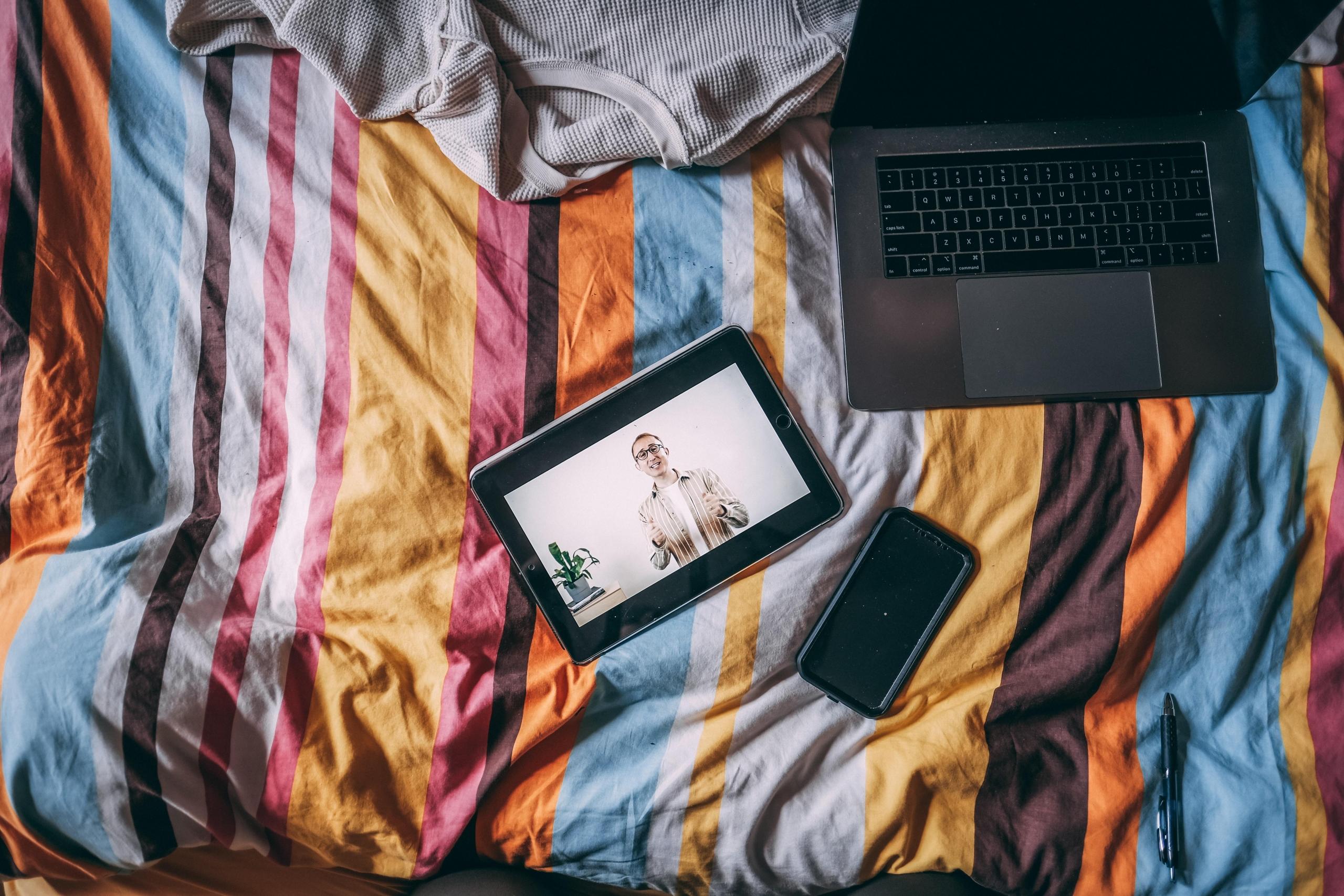Taptop, tablet i telefon w pościeli.