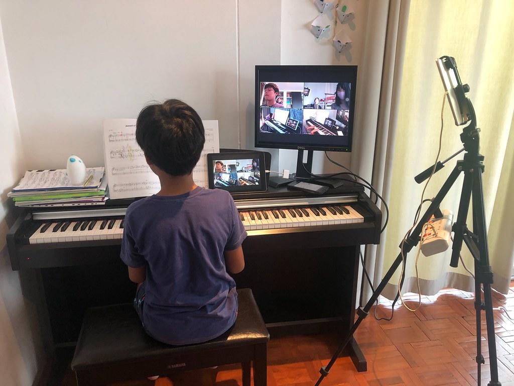 chłopiec grający na pianinie podczas zdalnych lekcji online