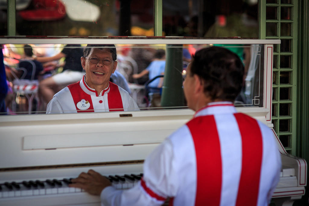 uśmiechnięty mężczyzna grający na pianinie
