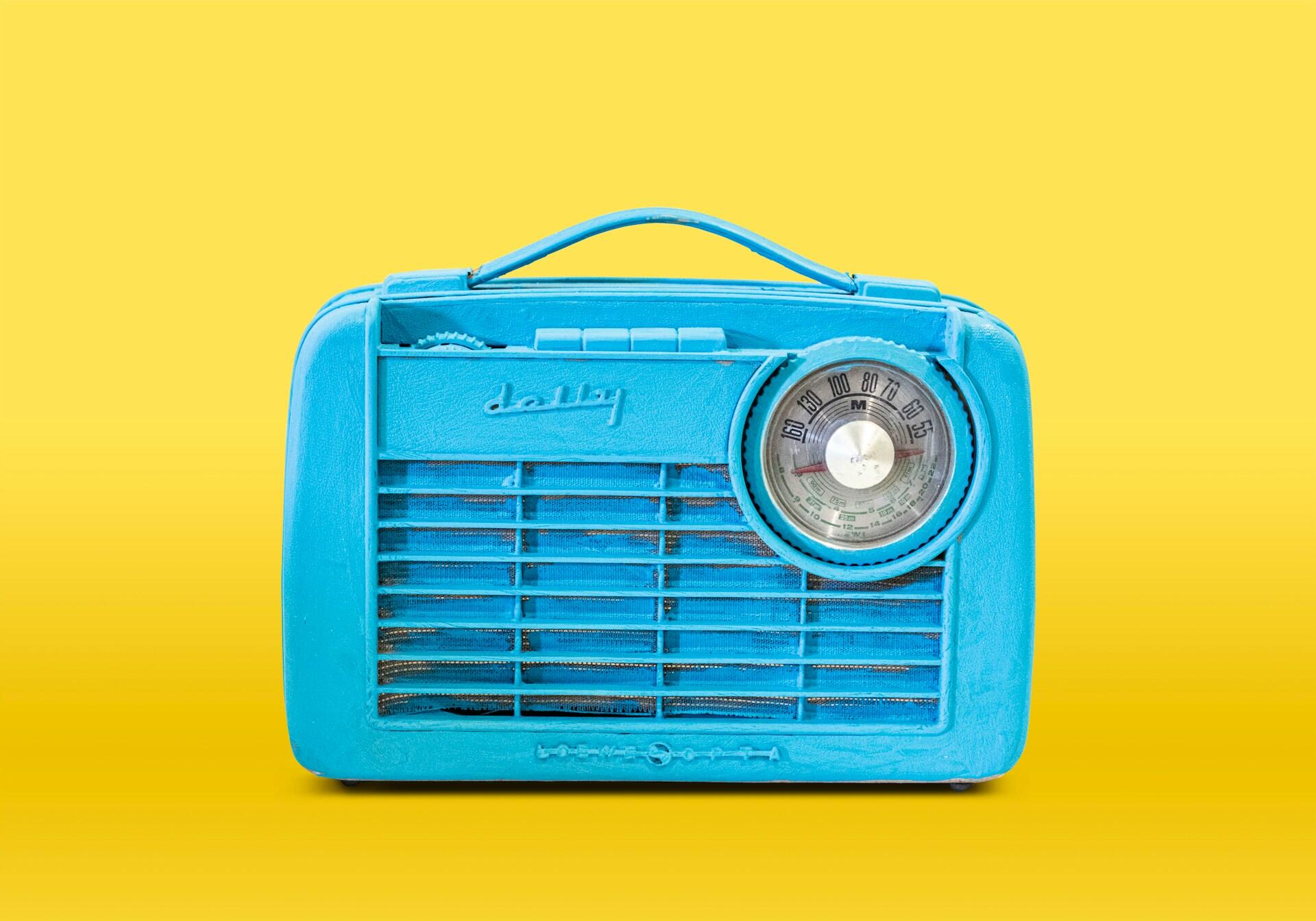 Niebieskie retro radio na żółtym tle.