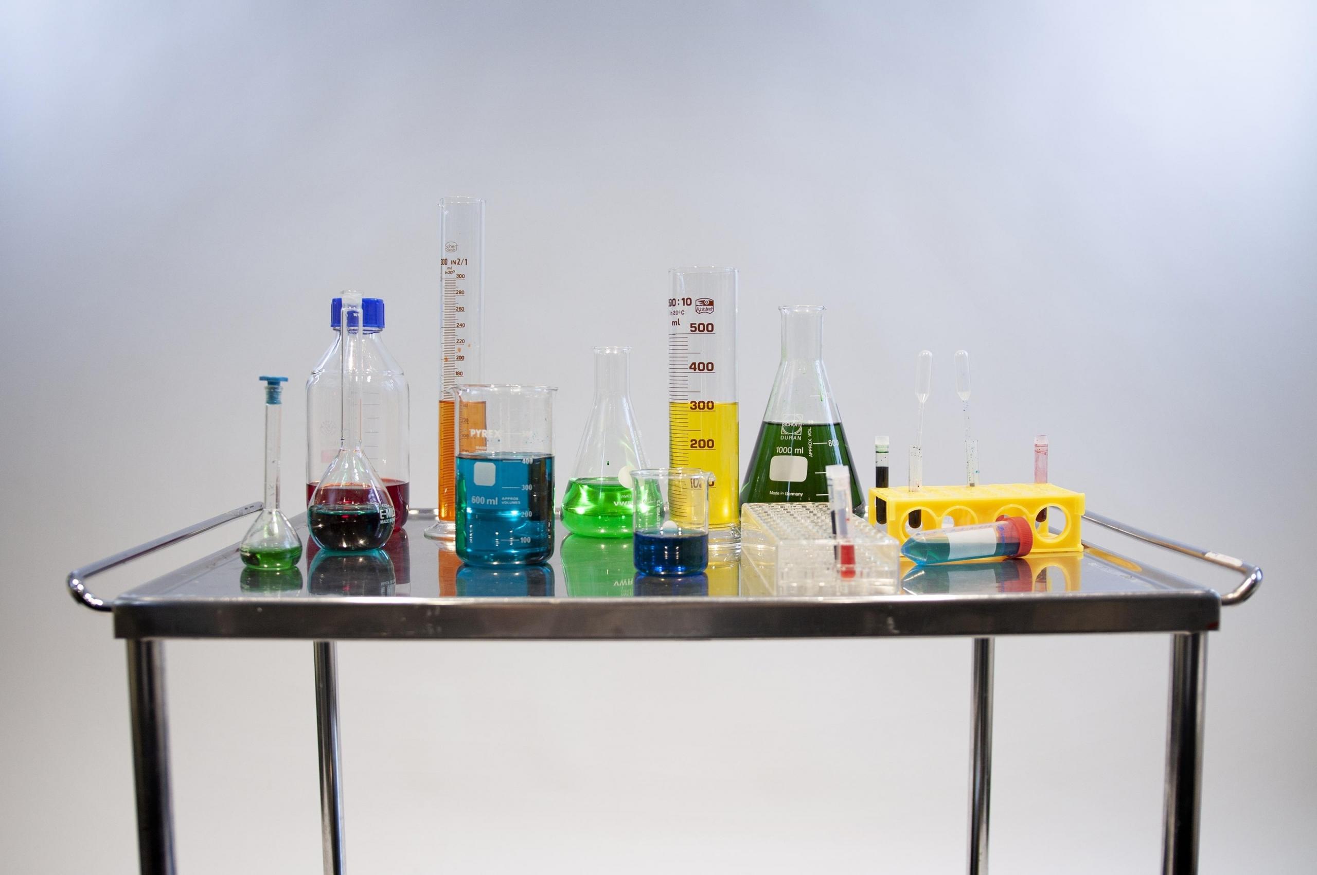 Stolik z różnymi płynami w kolbach i próbowkach chemicznych.