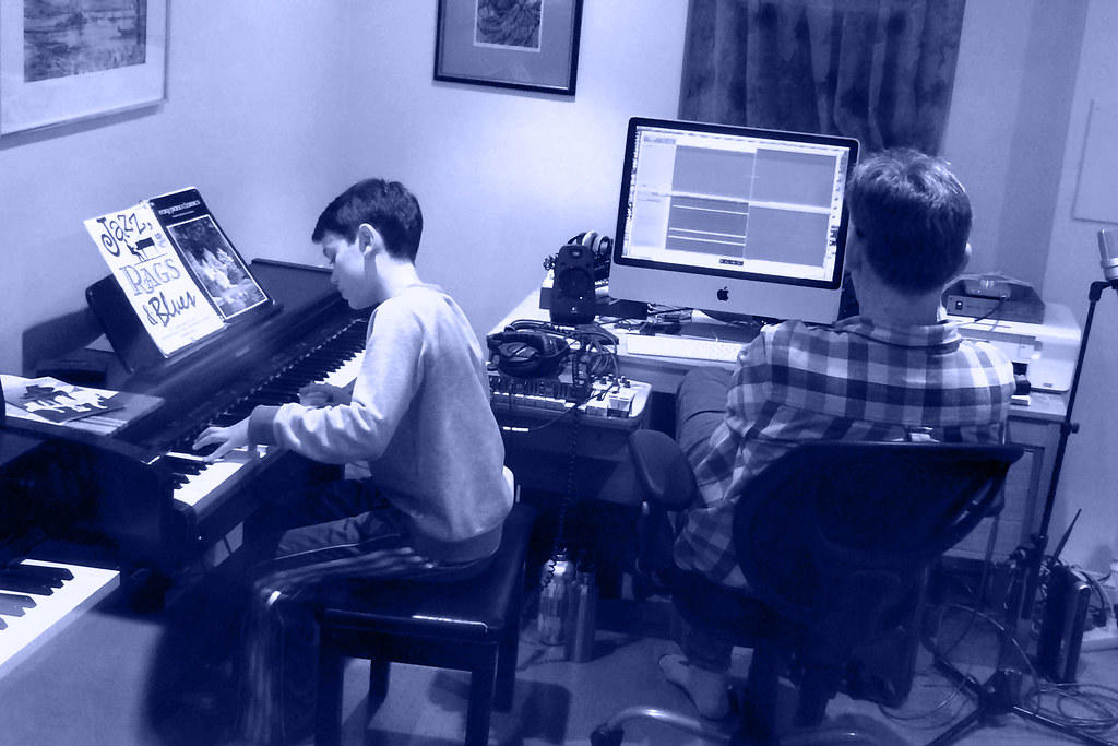 nauczyciel pilnujący chłopca grającego na pianinie