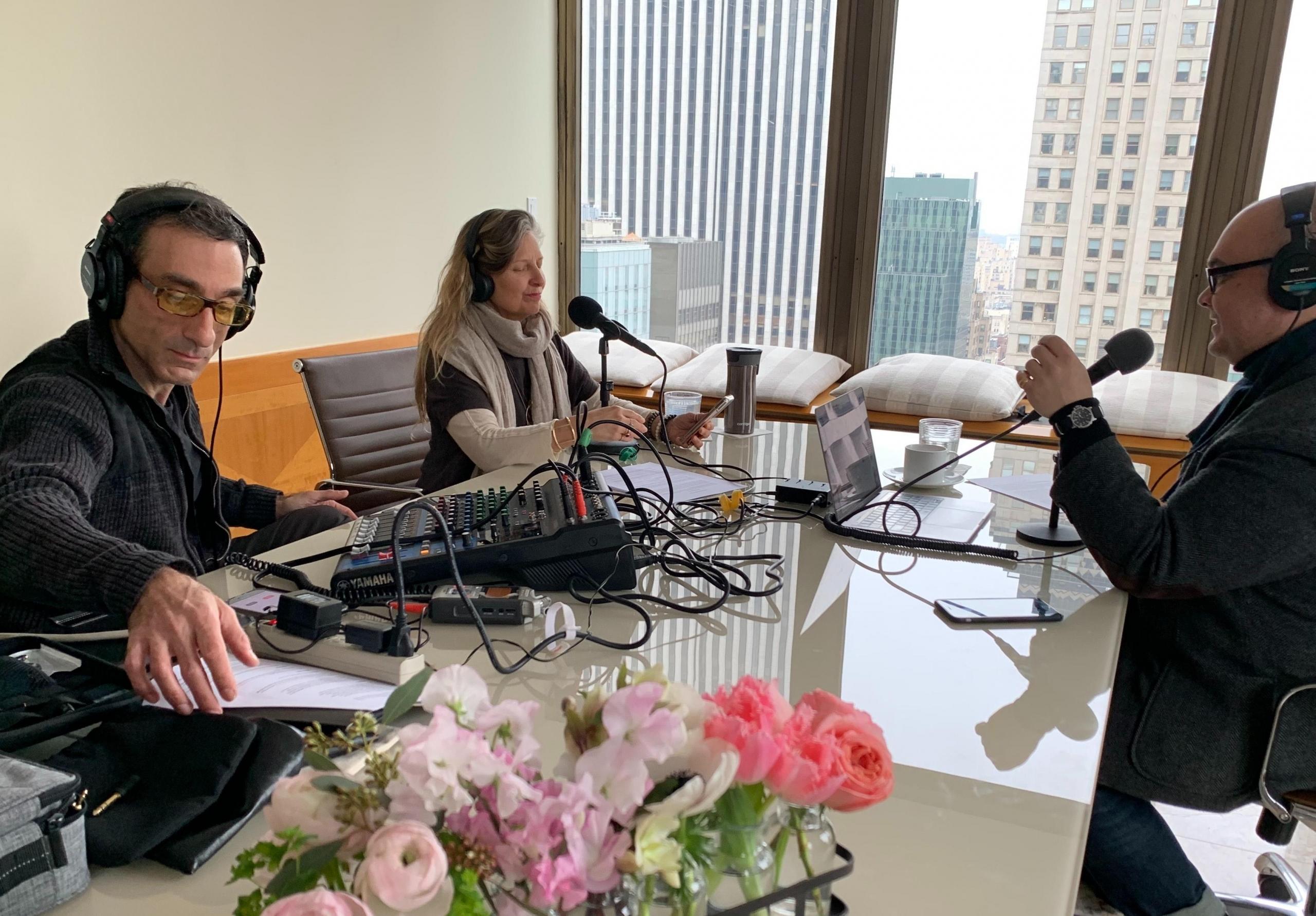 Ludzie przy stole, nagrywający podkast.